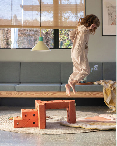 Toddler jumping off MODU jump tower, a fun activity toy for motor skill development. Built from Dreamer Set.